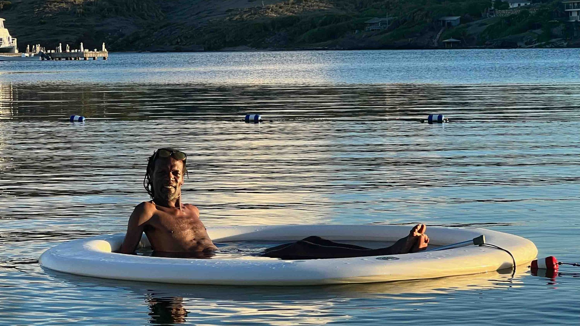 The writer's husband Shyne enjoys the water. He is sitting in a flotation device and smiling.