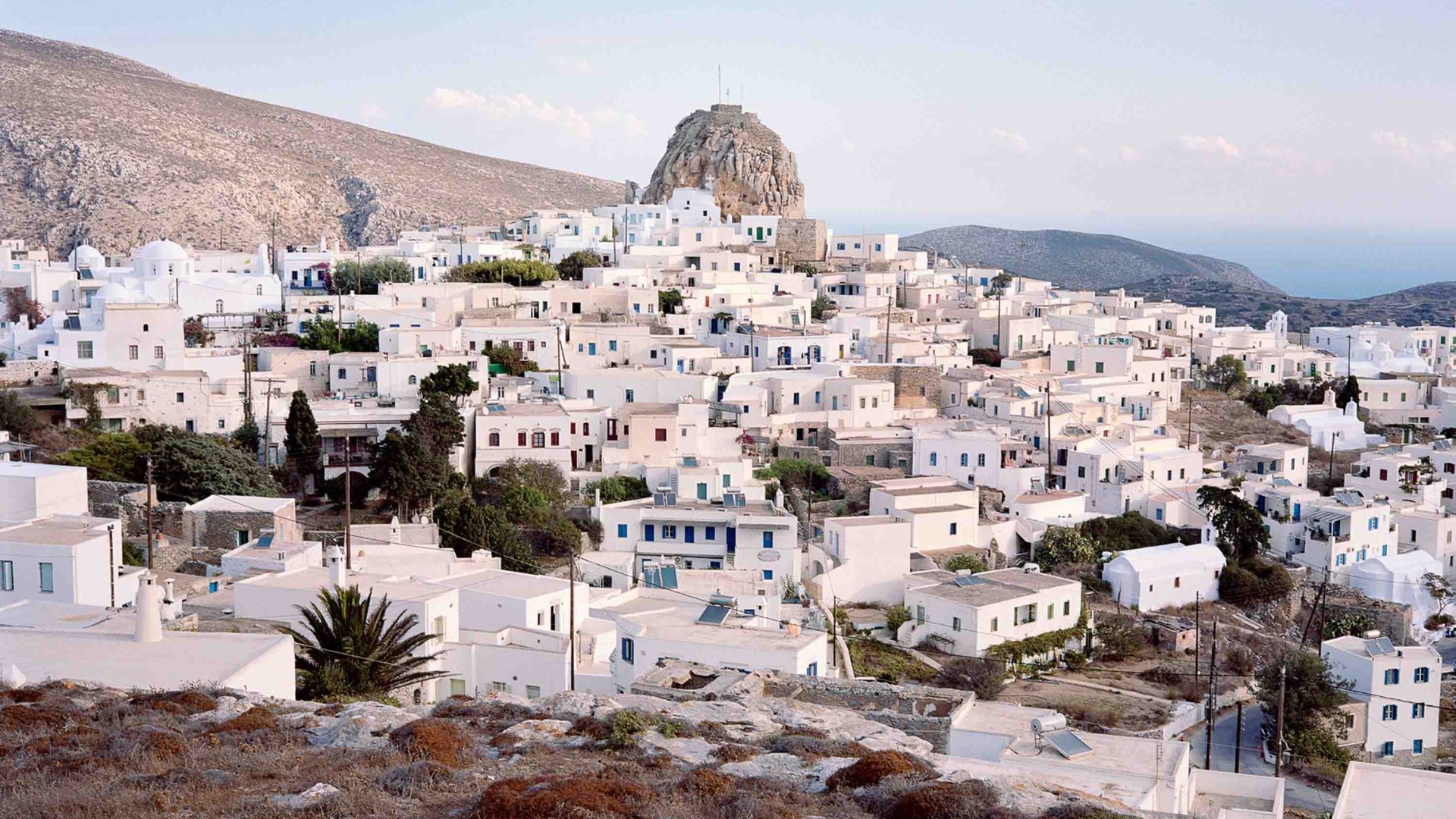 Looking down at white houses in a village .