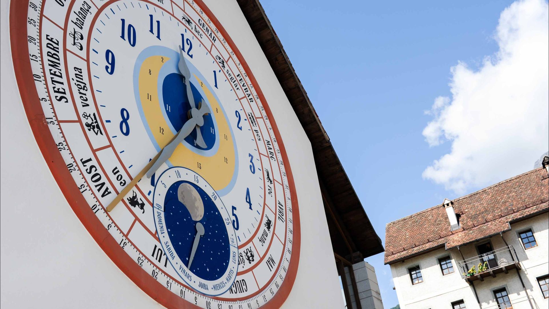 A clock on a wall of a building in Pesariis.